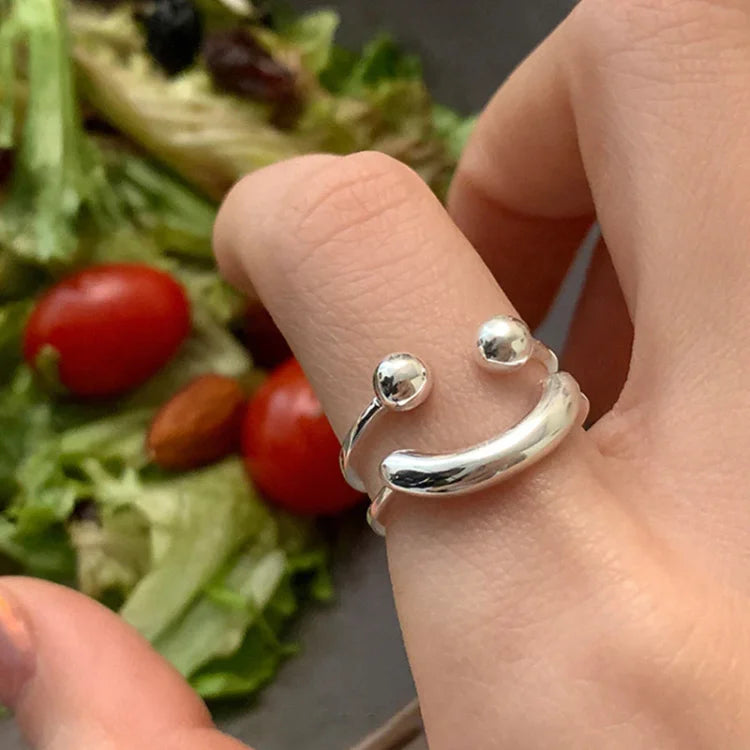 Silver adjustable smiley ring for women, a fun and modern statement piece. Ideal playful accessory.