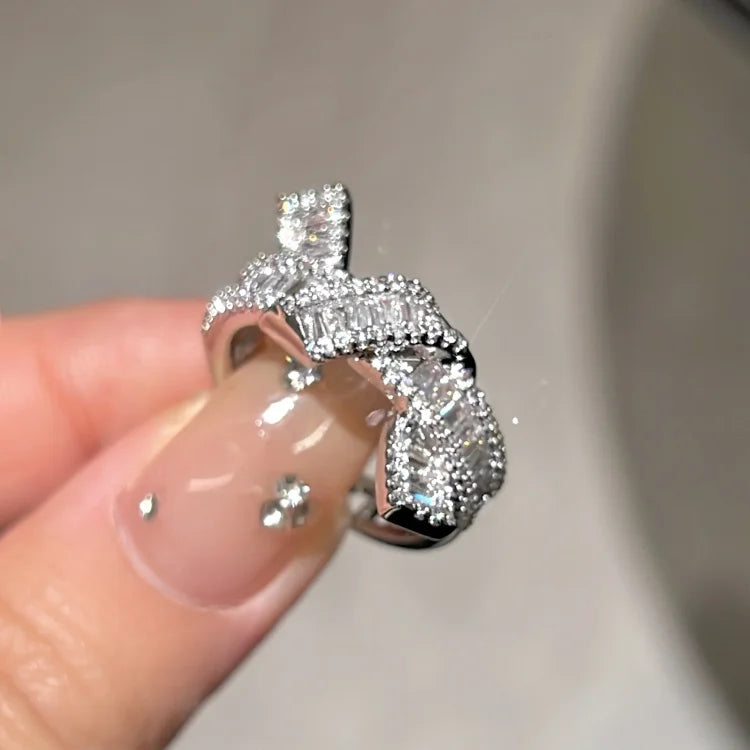 Fashionable women's adjustable silver ring with intricate knot design and dazzling zirconia diamonds.