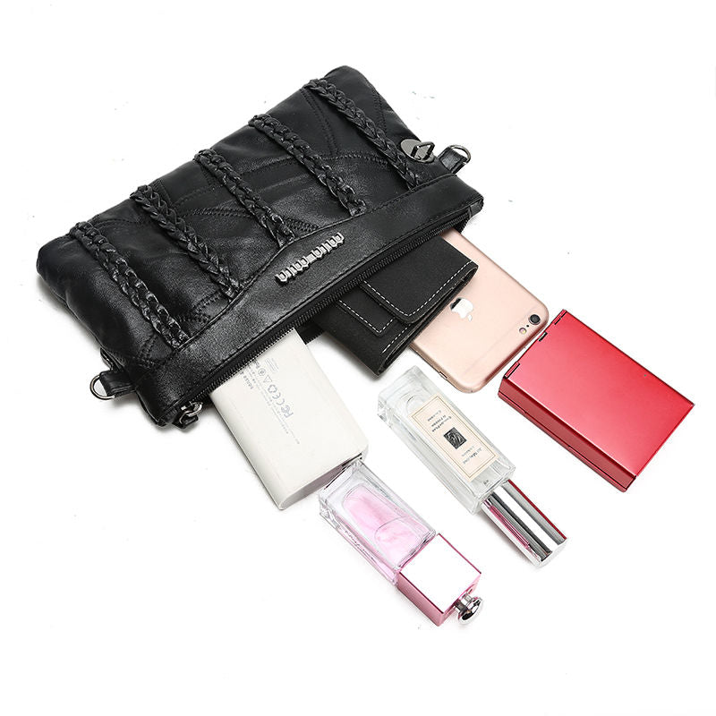 Close-up of black PU leather texture on women's crossbody clutch bag, quality material detail