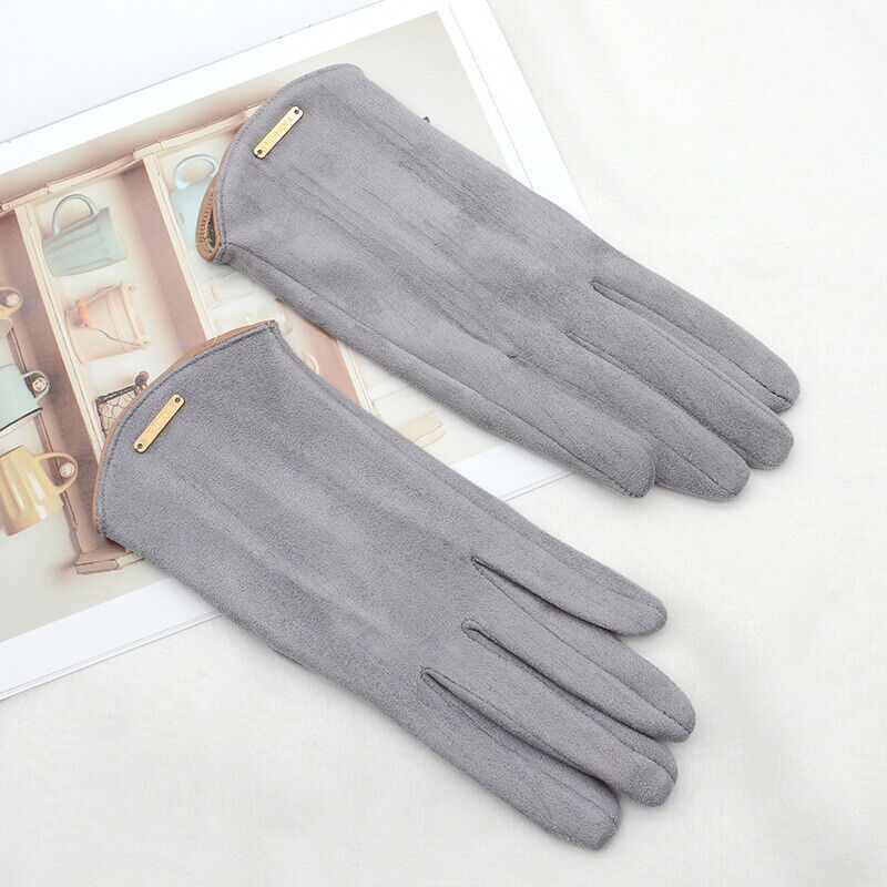 Close-up of a woman's hand wearing red suede cashmere gloves, showcasing touchscreen finger