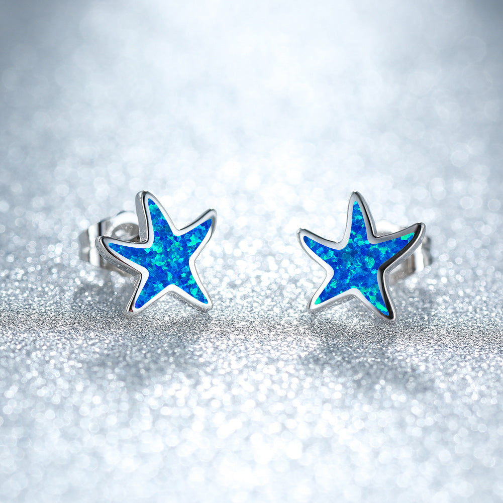 Women's blue opal starfish earrings in sterling silver, delicate ocean-inspired jewelry.