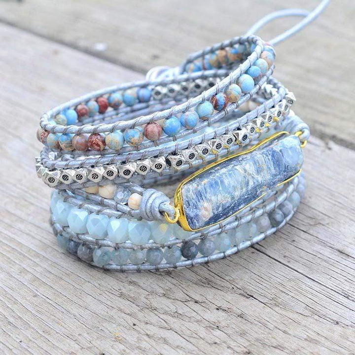 Close-up of women's blue topaz healing wrap bracelet with natural stones