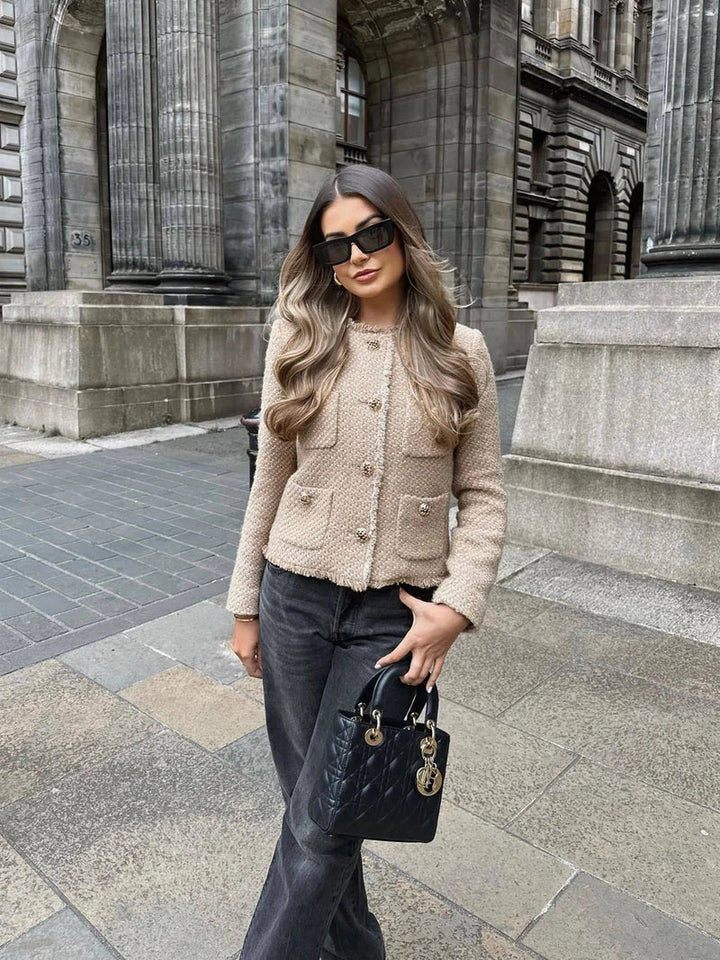 Elegant women's beige jacket featuring prominent gold buttons. A chic tweed blazer for a sophisticated look.