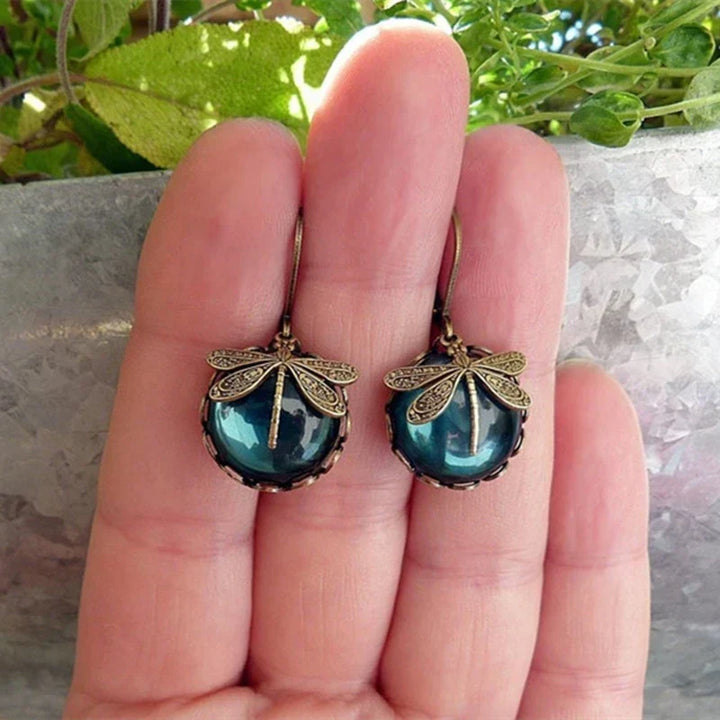 Dainty antique gold dragonfly earrings for women. Exquisite vintage-style jewelry with a nature-inspired design.