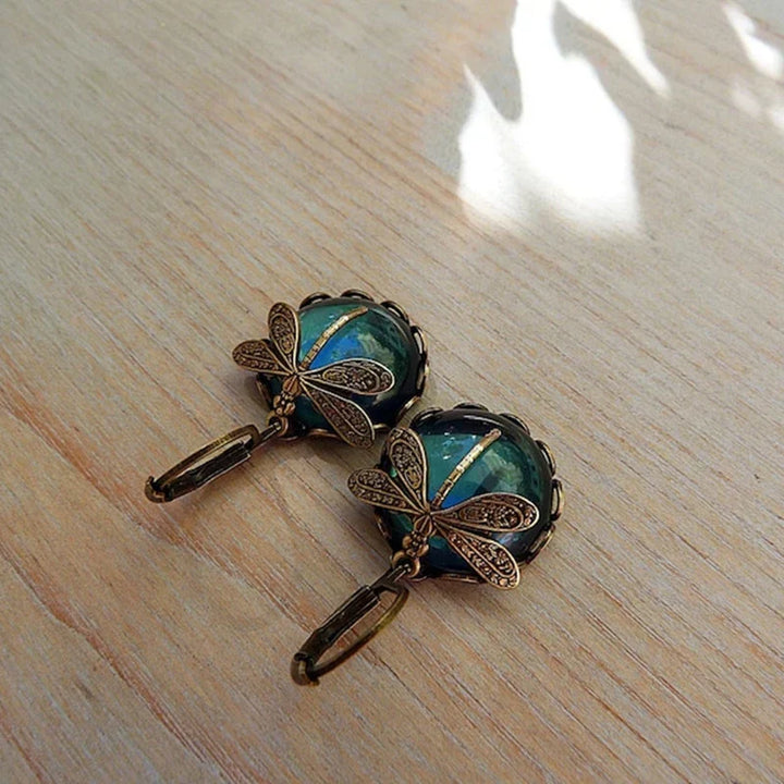 Detailed antique gold dragonfly earrings. Elegant vintage women's jewelry, unique nature-inspired motif.