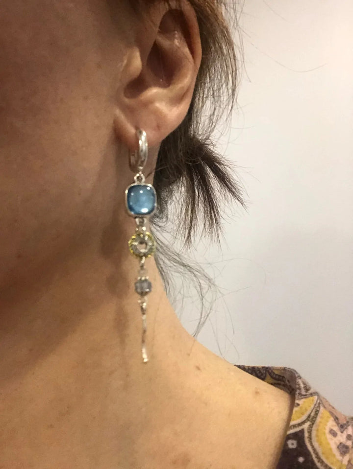 Symbolic blue gemstone cross dangle earrings for women, elegant jewelry featuring beautiful blue stones.
