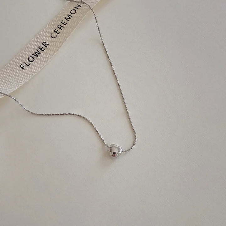 Versatile minimalist heart necklace, elegant dainty design. Perfect women's jewelry in sleek silver.
