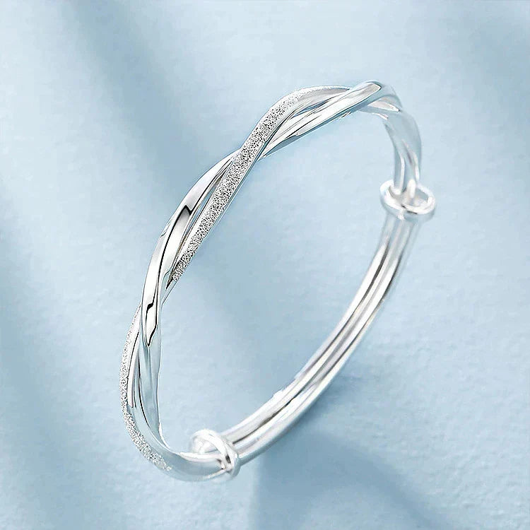 Detailed view of an elegant women's sterling silver bracelet, featuring a unique intricate design & adjustable fit.