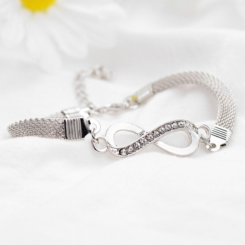 Woman's hand showcasing an elegant sterling silver infinity bracelet, a timeless jewelry gift.