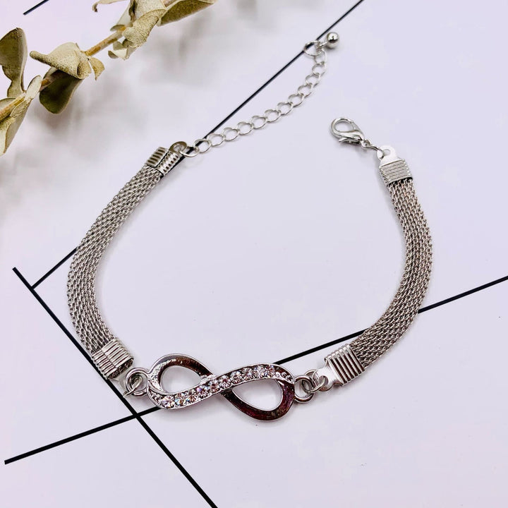 Elegant sterling silver infinity bracelet adds a touch of timeless style to a woman's outfit.