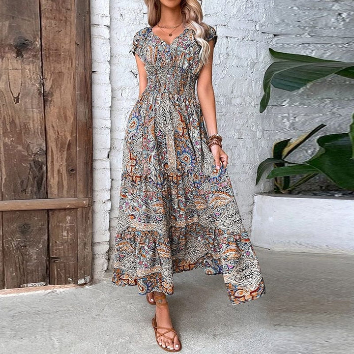 Close-up of the vibrant ethnic print on the flowy V-neck maxi dress fabric. Summer casual wear.