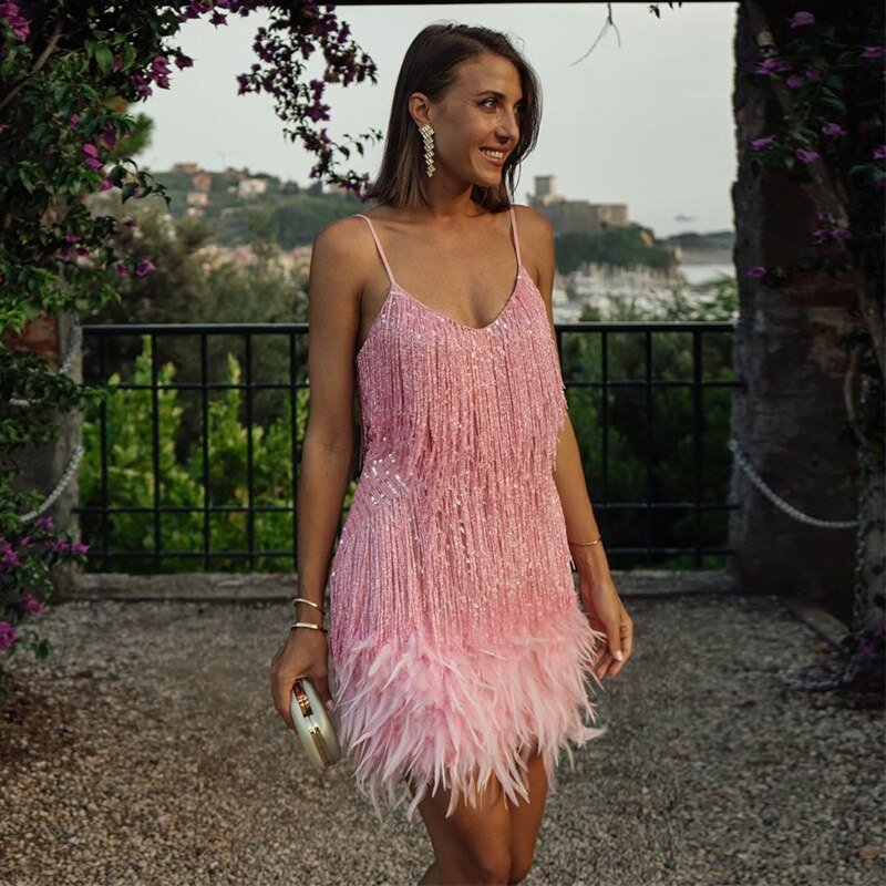Women's elegant spaghetti strap sequin dress with feather hem for a glamorous special occasion.