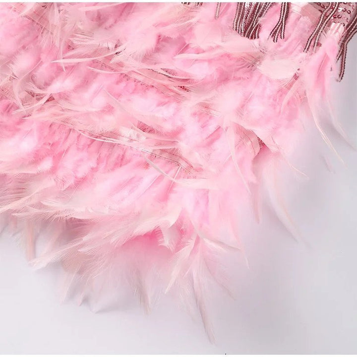Short women's sequin party dress, featuring a glamorous feather hem, ideal for cocktails & dancing.