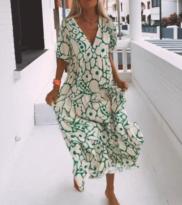 Women's vibrant green floral pattern maxi dress, short sleeves. Chic V-neck design, perfect for warm weather.