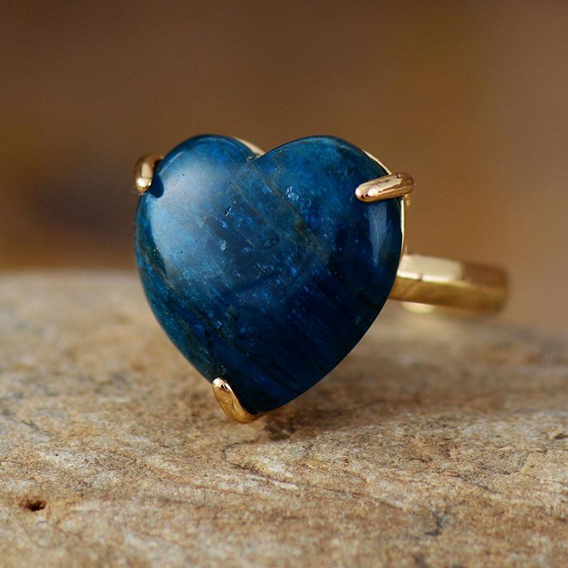 Close-up of a women's healing heart ring featuring a lustrous apatite gemstone. Handmade, adjustable.