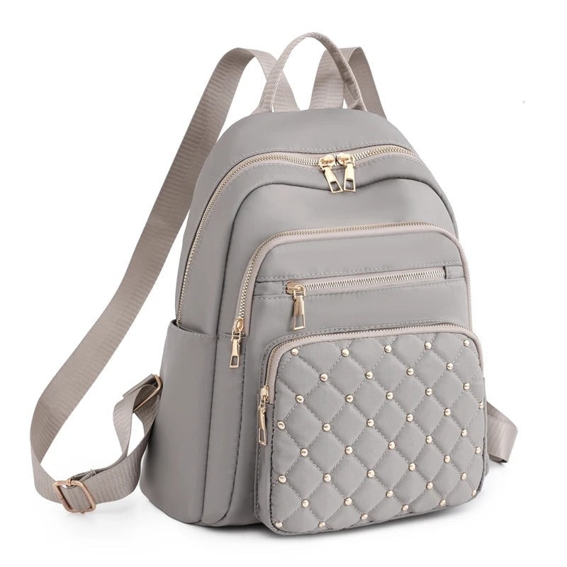 Front view of women's water-resistant nylon backpack with multiple pockets. Ideal lightweight travel & school bag.