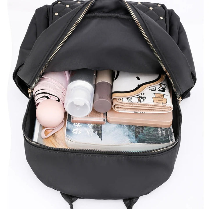 Woman wearing lightweight water-resistant nylon travel backpack in an airport. Stylish & practical for her journey.