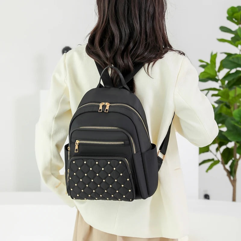 Back view of women's lightweight nylon backpack with padded straps & breathable design. Comfortable for travel & daily commute.