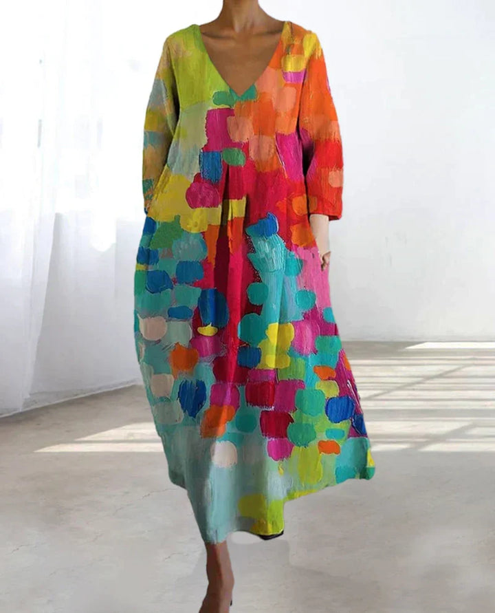 Vibrant colorful print on a flowy Women's Livia V-neck maxi dress, offering elegant casual chic for spring/summer.
