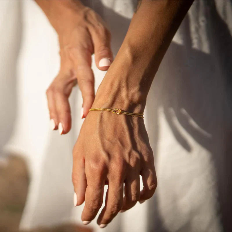 Gold-tone minimalist knot bracelet, a fashionable accessory for women.