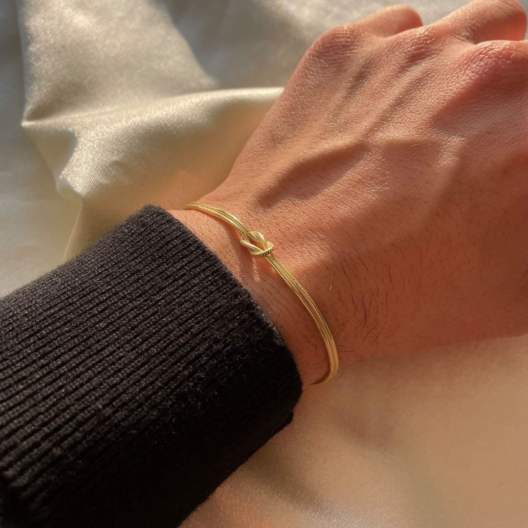 Women's delicate gold knot bracelet, perfect for a subtle, elegant look.