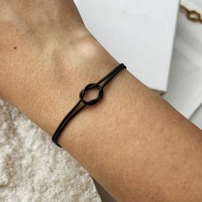 Women's stackable gold knot bracelet, a key minimalist jewelry piece.