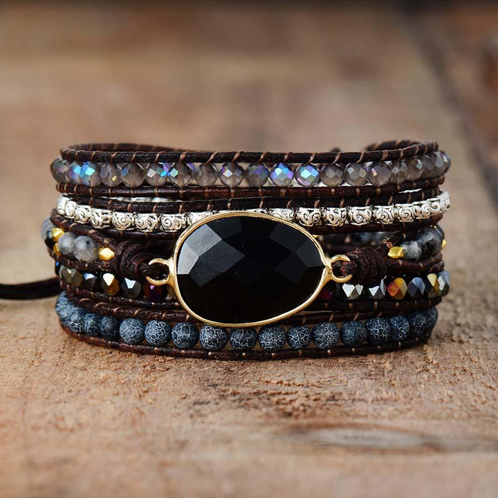 Close-up of a women's onyx and quartz wrap bracelet, showcasing natural black and clear healing stones.
