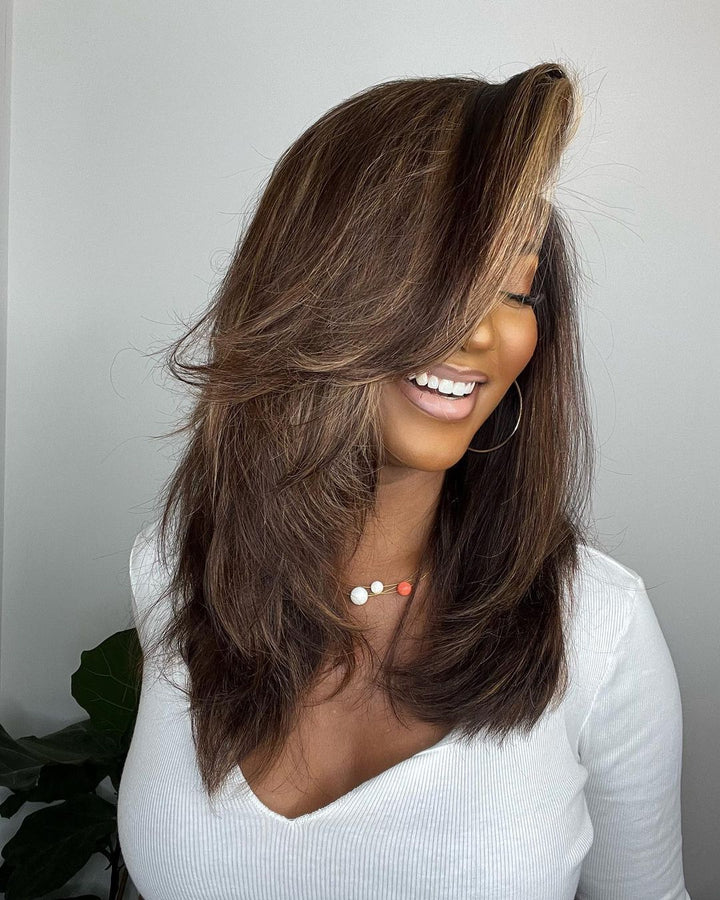 Brown human hair lace front wig featuring trendy blonde highlights. Wavy texture provides a natural, full appearance.