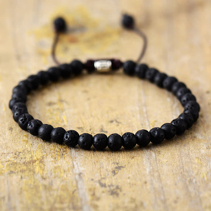 Model wearing a women's natural stone & pearl adjustable braided bracelet. Trendy gemstone jewelry.