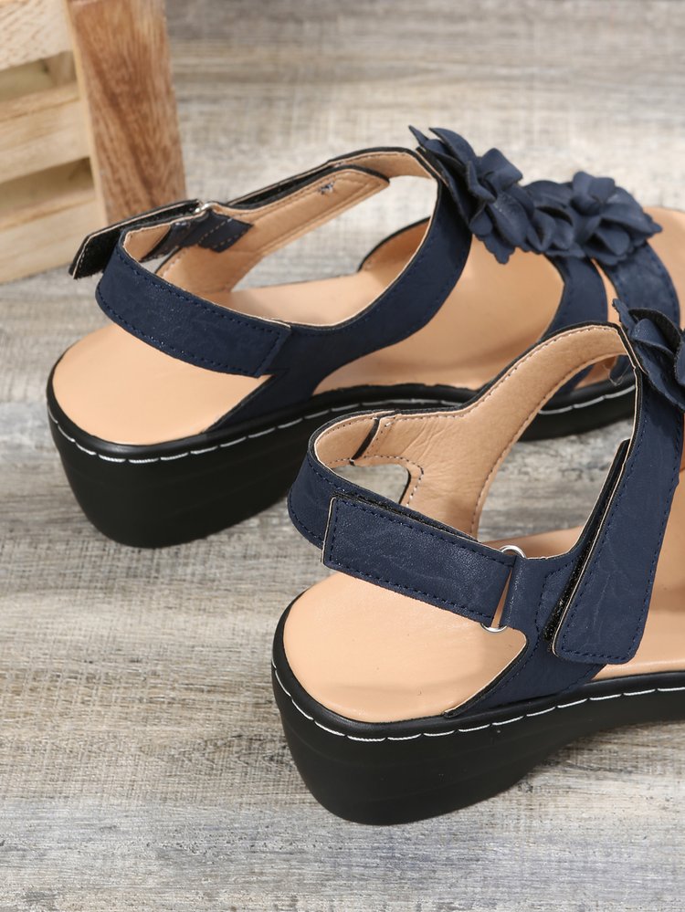 Close-up of the sole and orthopedic arch support of women's gladiator sandals with floral motif, wedge heel