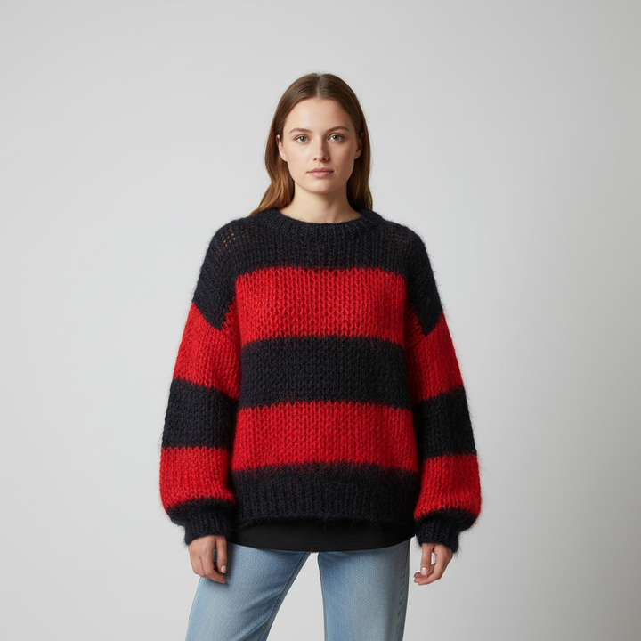 Fashionable women's oversized knit sweater featuring a bold stripe pattern, suitable for relaxed settings.