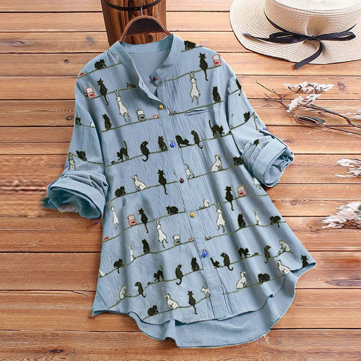 Colorful ladies' blouse featuring playful cat print. Long sleeve, button-down for stylish everyday comfort.