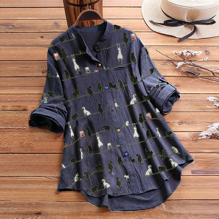 Close-up of women's long sleeve button-down blouse, highlighting playful cat print & comfortable fabric.