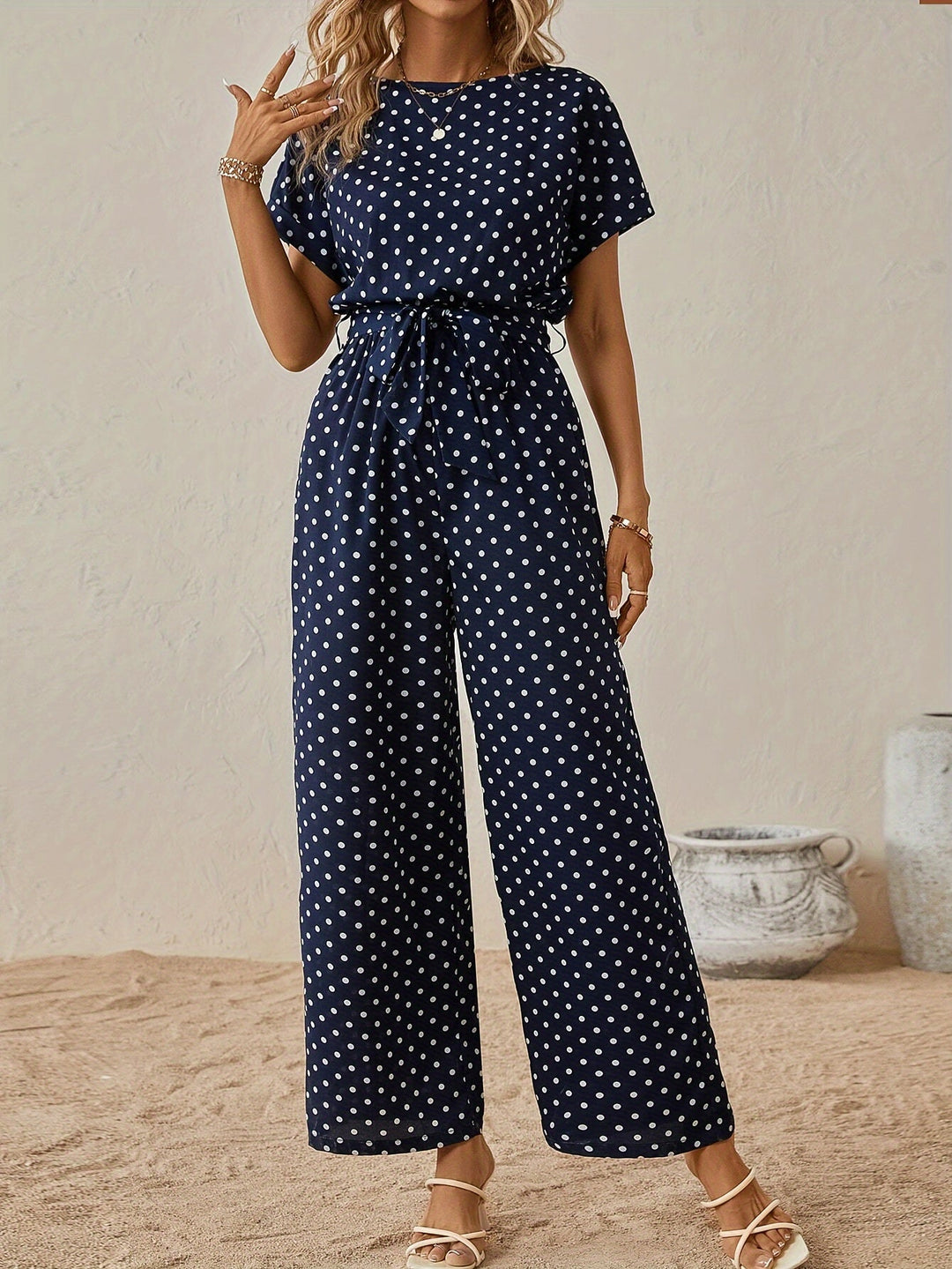 Women's polka dot jumpsuit with elastic waist, short sleeves, and wide legs, ideal for summer fashion.
