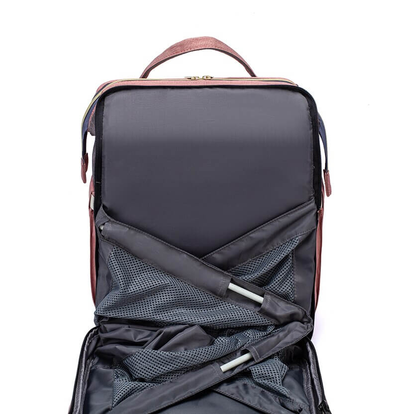 Secure portable baby bed within a multi-function diaper bag backpack for safe infant naps.