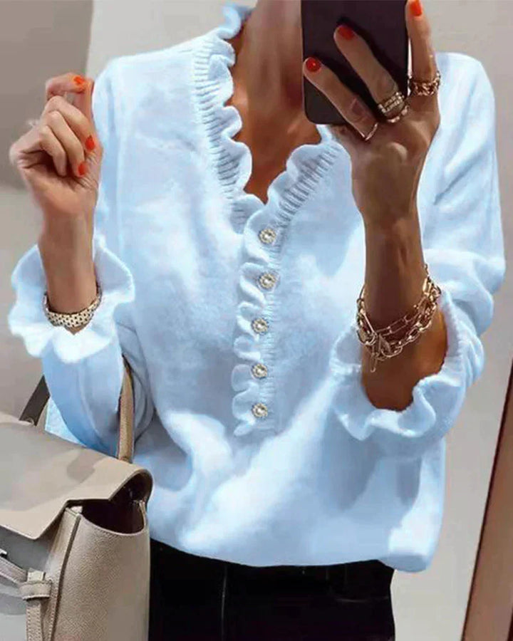 Women's ruffled knit sweater with elegant button details. Cozy long sleeve top for chic casual wear.