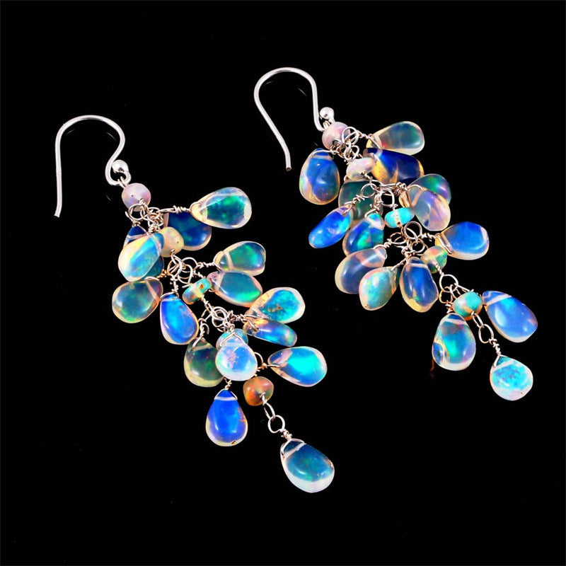 Close-up of elegant women's moonstone dangle earrings. Features natural, iridescent gemstone in a silver setting.