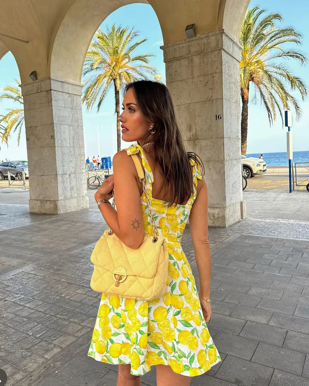 Vibrant lemon print summer dress for women. Sleeveless and flowy, ideal for beachwear, parties, or casual fashion.