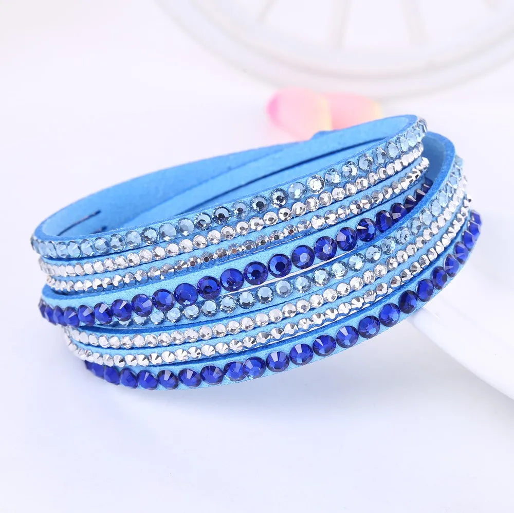 Hand modeling a women's sparkling layered rhinestone wrap bracelet, showing its shimmer.