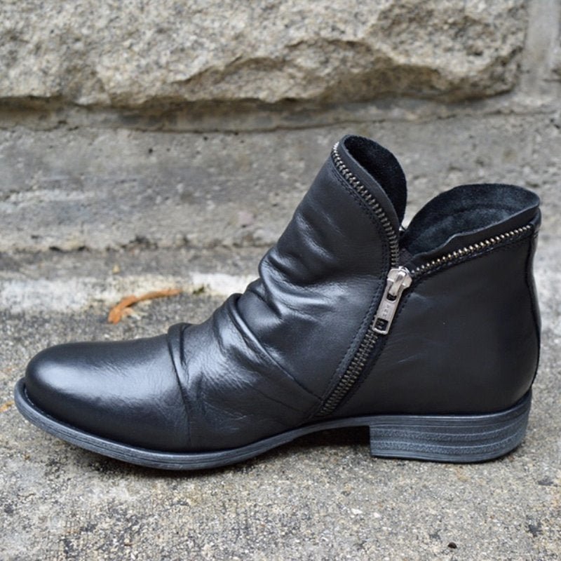 Women's trendy black leather ankle boots with zipper closure, sleek modern design for versatile fashion.