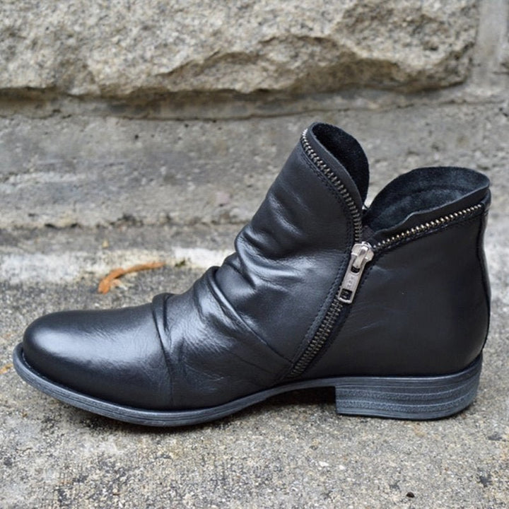 Women's trendy black leather ankle boots with zipper closure, sleek modern design for versatile fashion.
