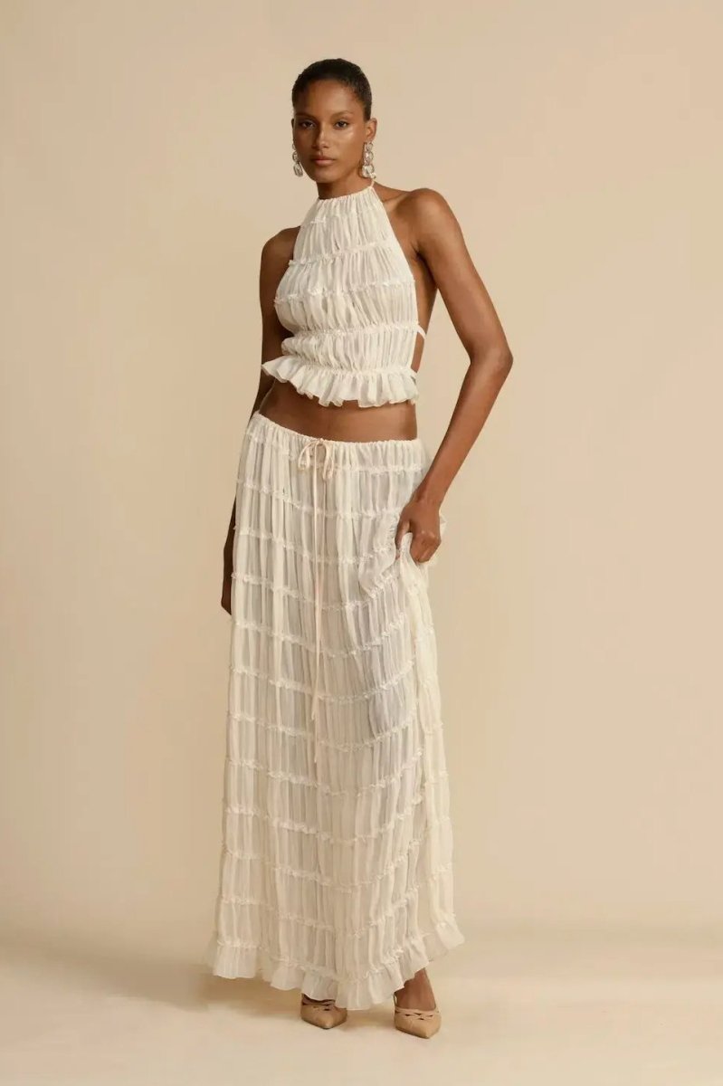Fashionable women's halter top and flowy maxi skirt two-piece set, ideal for a chic summer outfit.