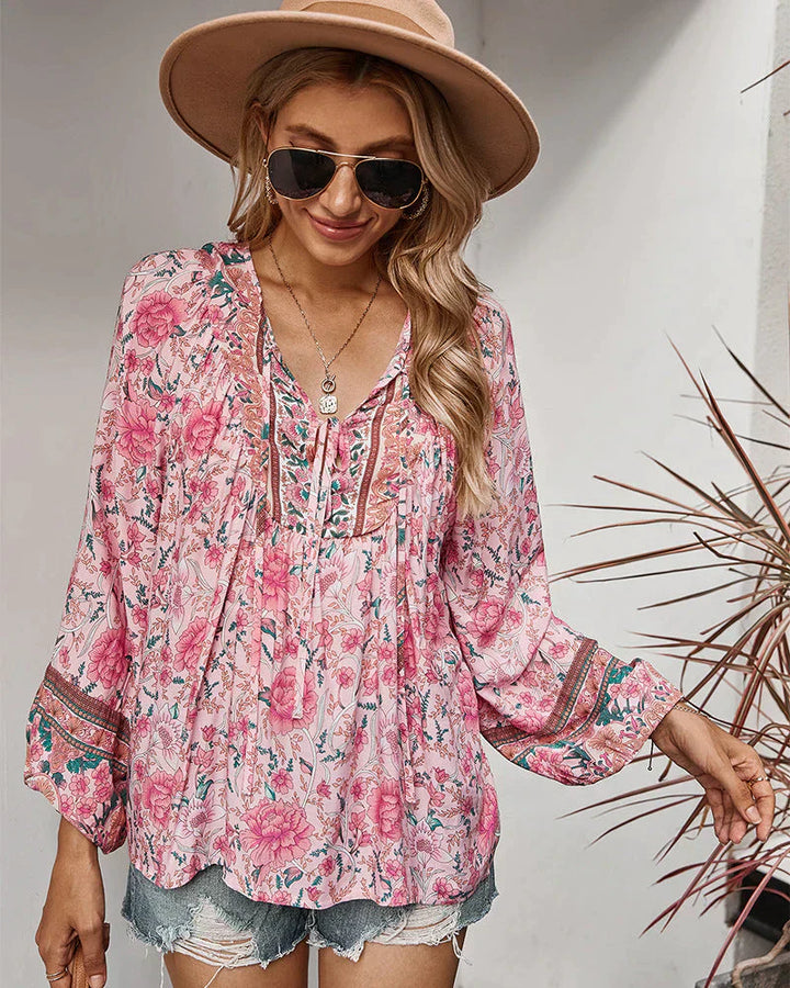 Close-up of women's boho floral print summer blouse with long sleeves and v-neck design.