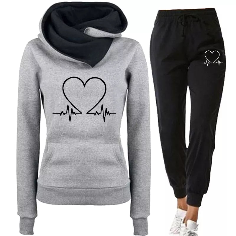Lifestyle shot: Woman wearing WARMFLEX cozy two-piece tracksuit at home, perfect loungewear comfort.