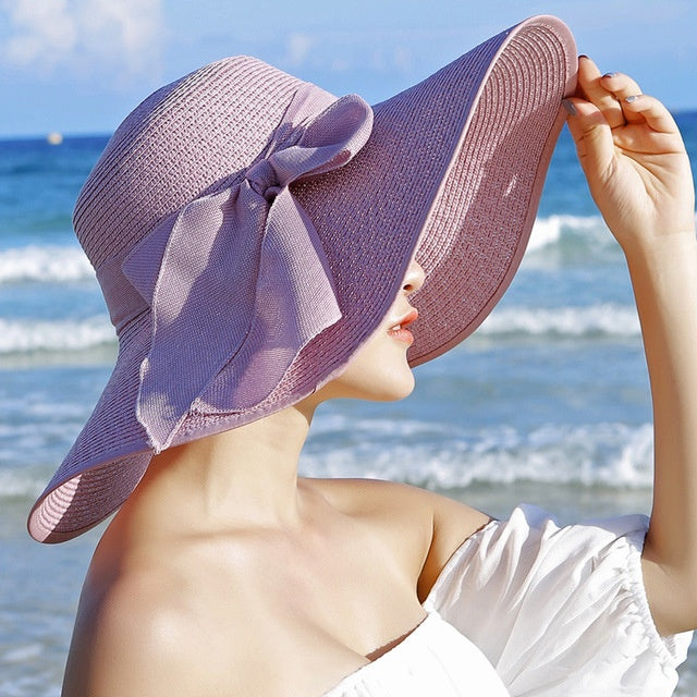 Elegant women's wide brim straw hat, sun protection, perfect for fashion-conscious ladies at the beach