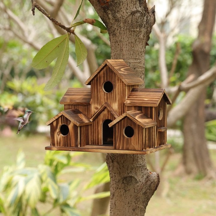 Garden scene with Nestora wooden birdhouse integrated into natural landscape